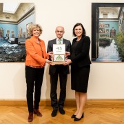 KHM-Direktorin Sabine Haag (link) und Ministerin Elisabeth Köstinger (rechts) übergeben Umweltdachverband-Präsident Franz Maier eine Geburtstagstorte